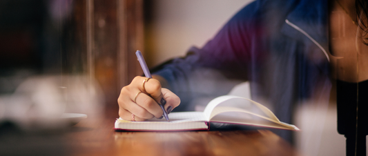 Person writing in sleep journal before bed Checklist of healthy sleep hygiene habits next to cozy bed Peaceful bedroom showing ideal sleep environment with blackout setup
