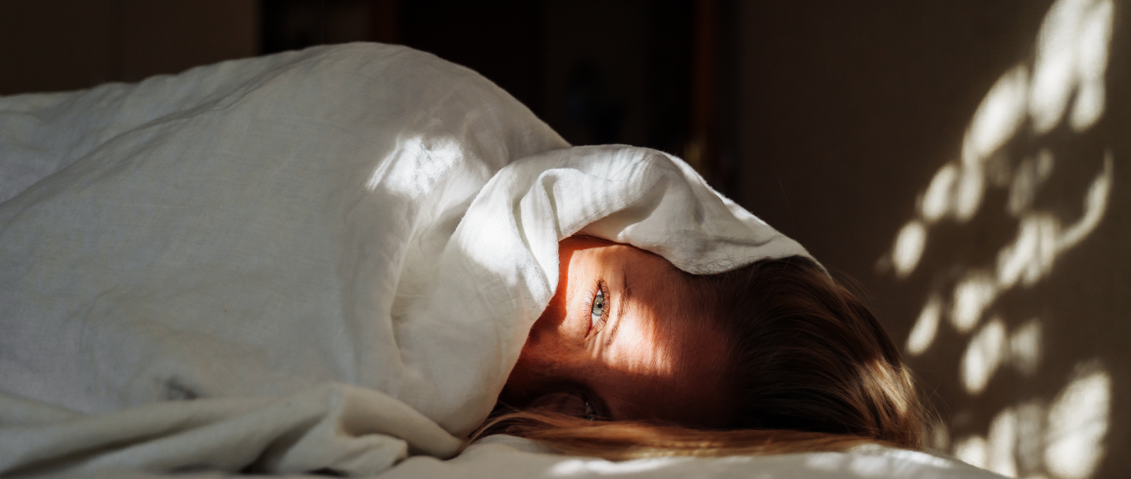 Person trying to sleep in a darkened room