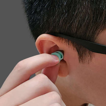 Person putting zDen Quiet the Chaos earplug in ear.