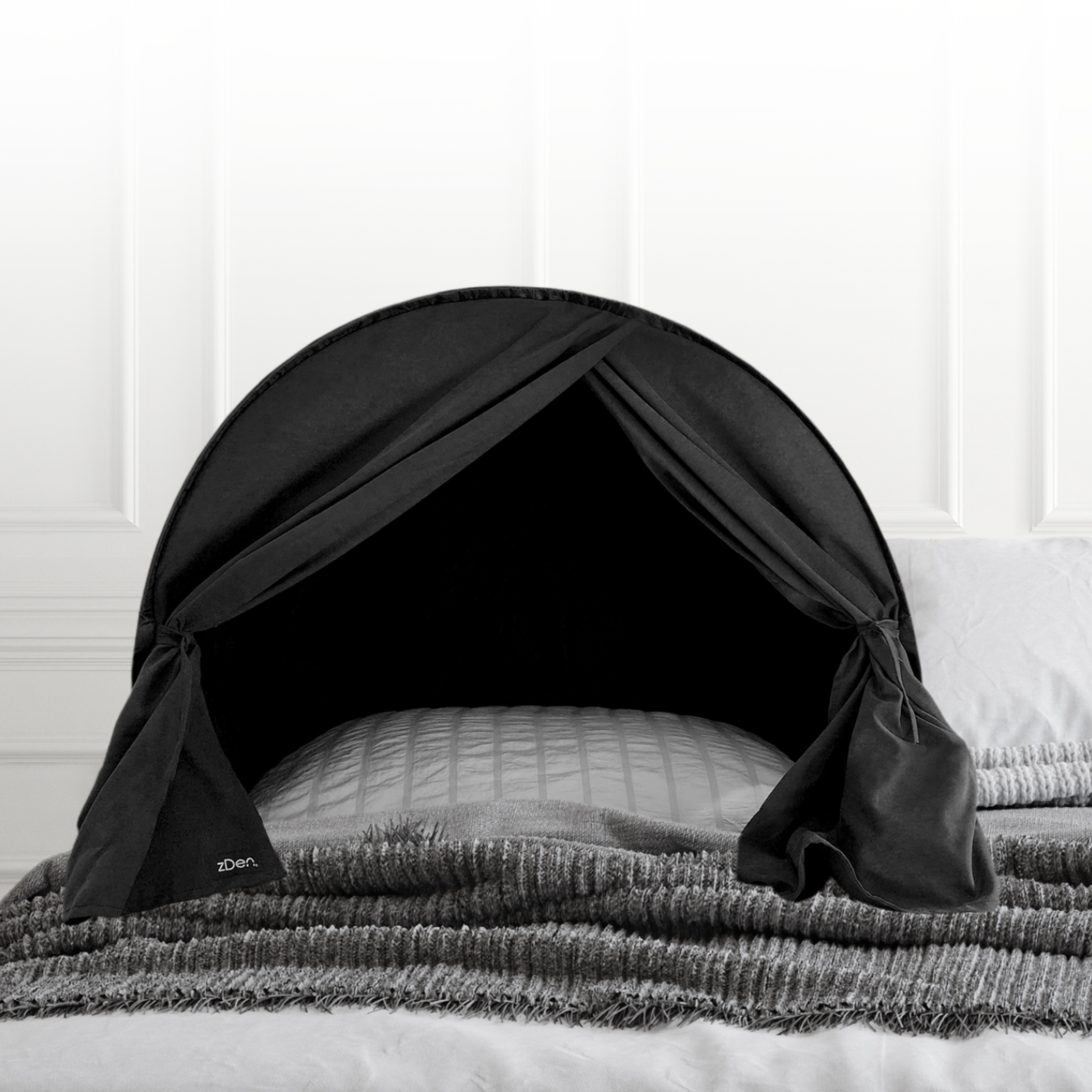 zDen light blocking upper body sleep tent on a bed with certification badges for Sleep Doctor approved, Patents and CPSC compliance.