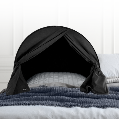 zDen light blocking upper body sleep tent on a bed with certification badges for Sleep Doctor approved, Patents and CPSC compliance.