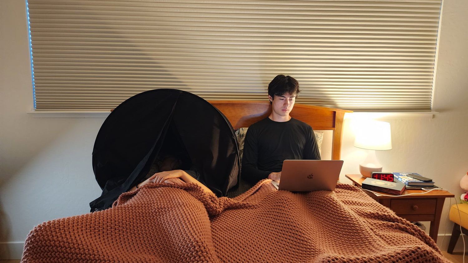 couple in bed, one awake and the other sleeping peacefully in a zDen